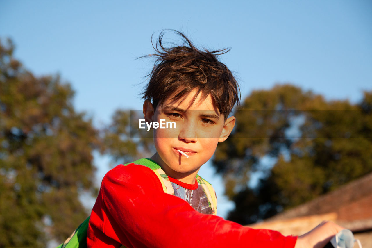 Portrait of boy eating lollipop outdoors