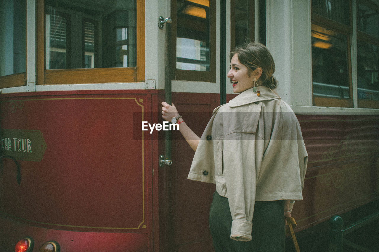 MIDSECTION OF WOMAN STANDING BY TRAIN WINDOW AT RAILROAD STATION