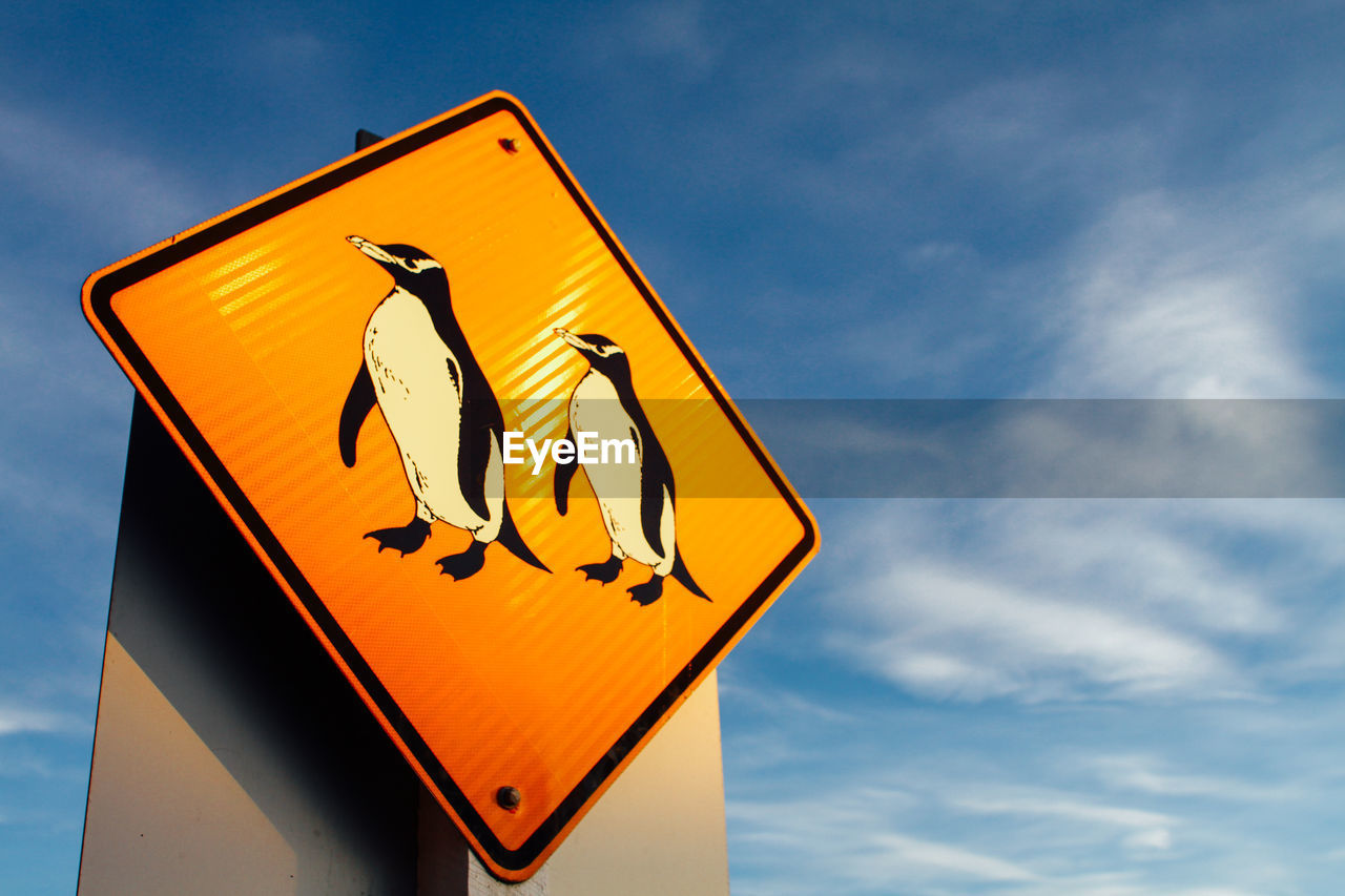 Low angle view of road sign against sky