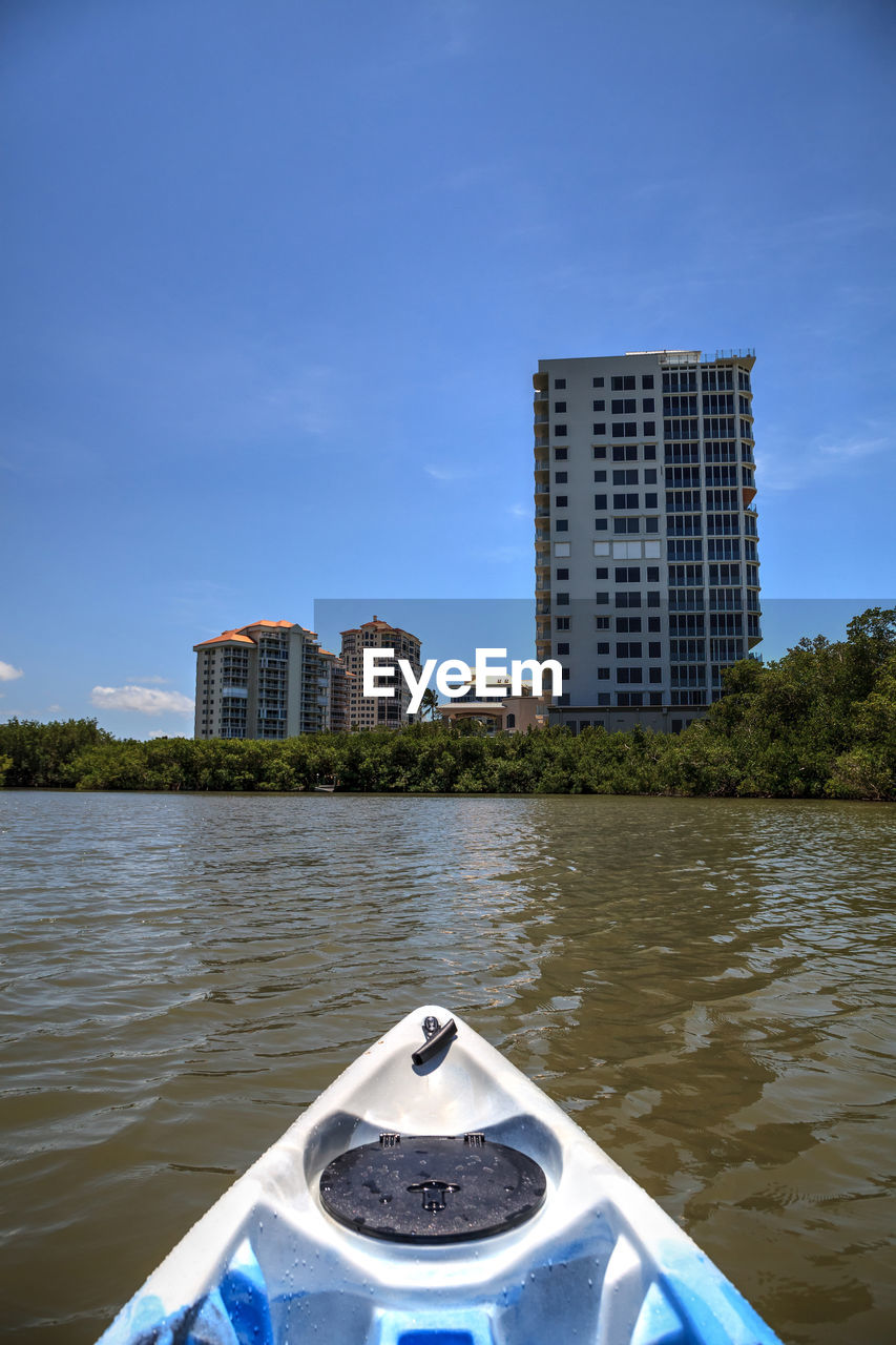 BUILDING BY RIVER AGAINST SKY