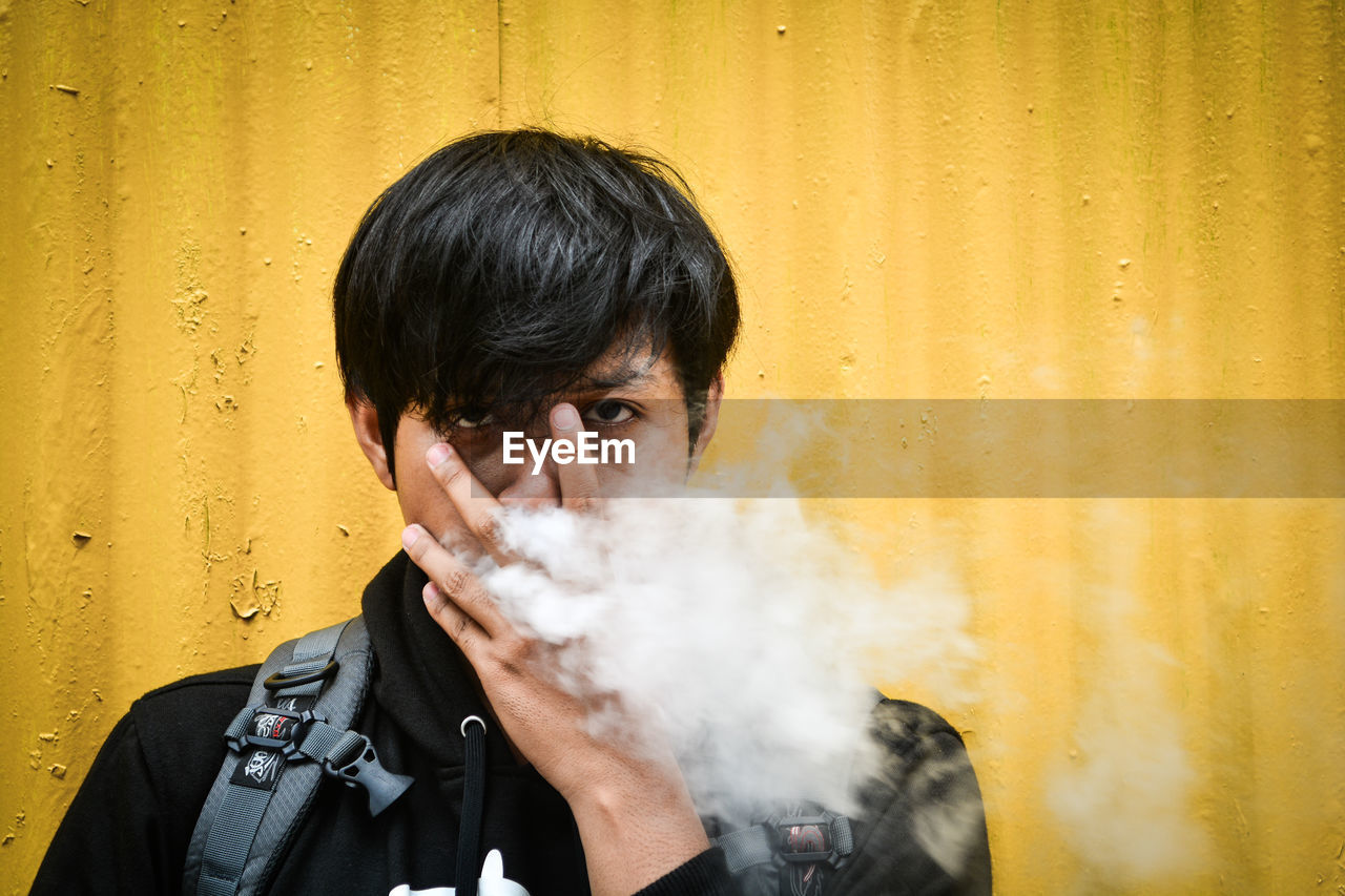 PORTRAIT OF MAN SMOKING CIGARETTE