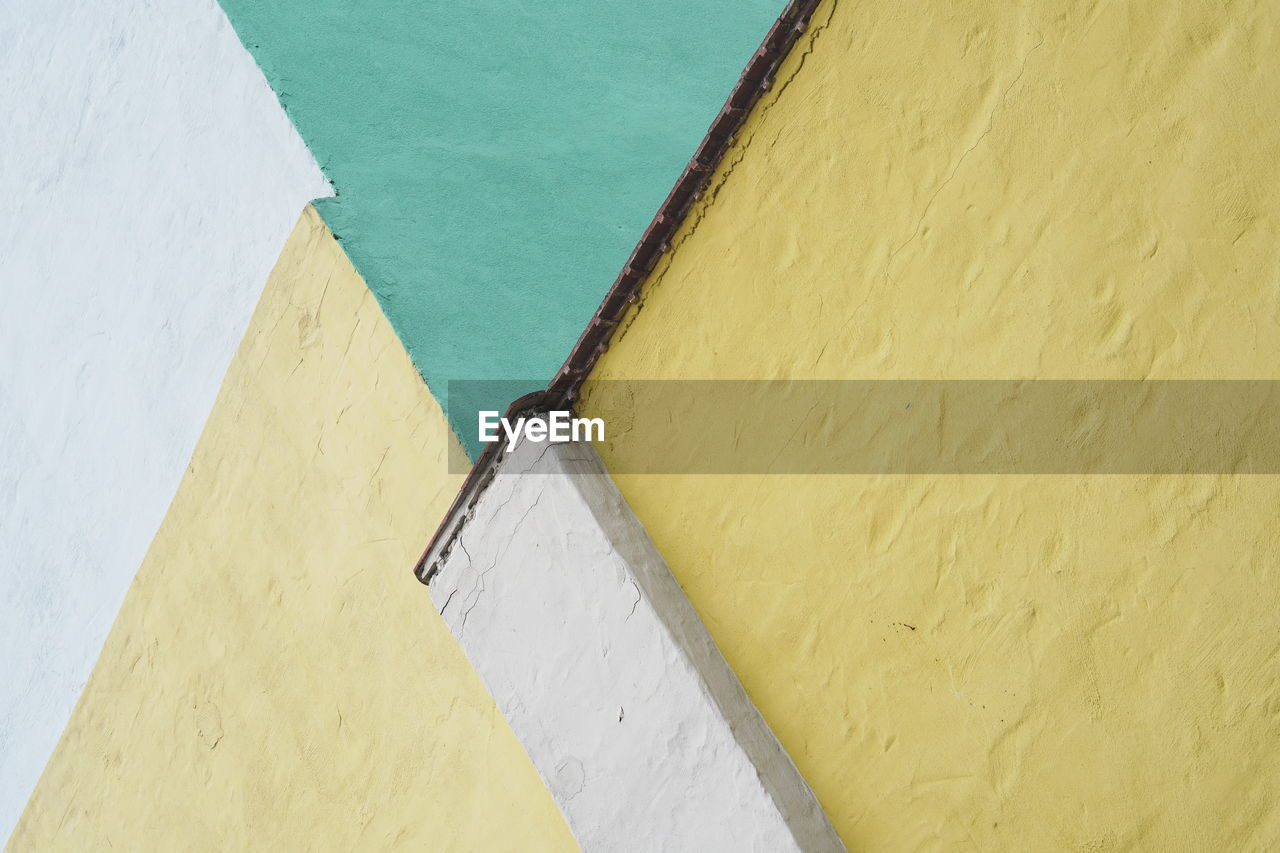 HIGH ANGLE VIEW OF WHITE WALL WITH UMBRELLA