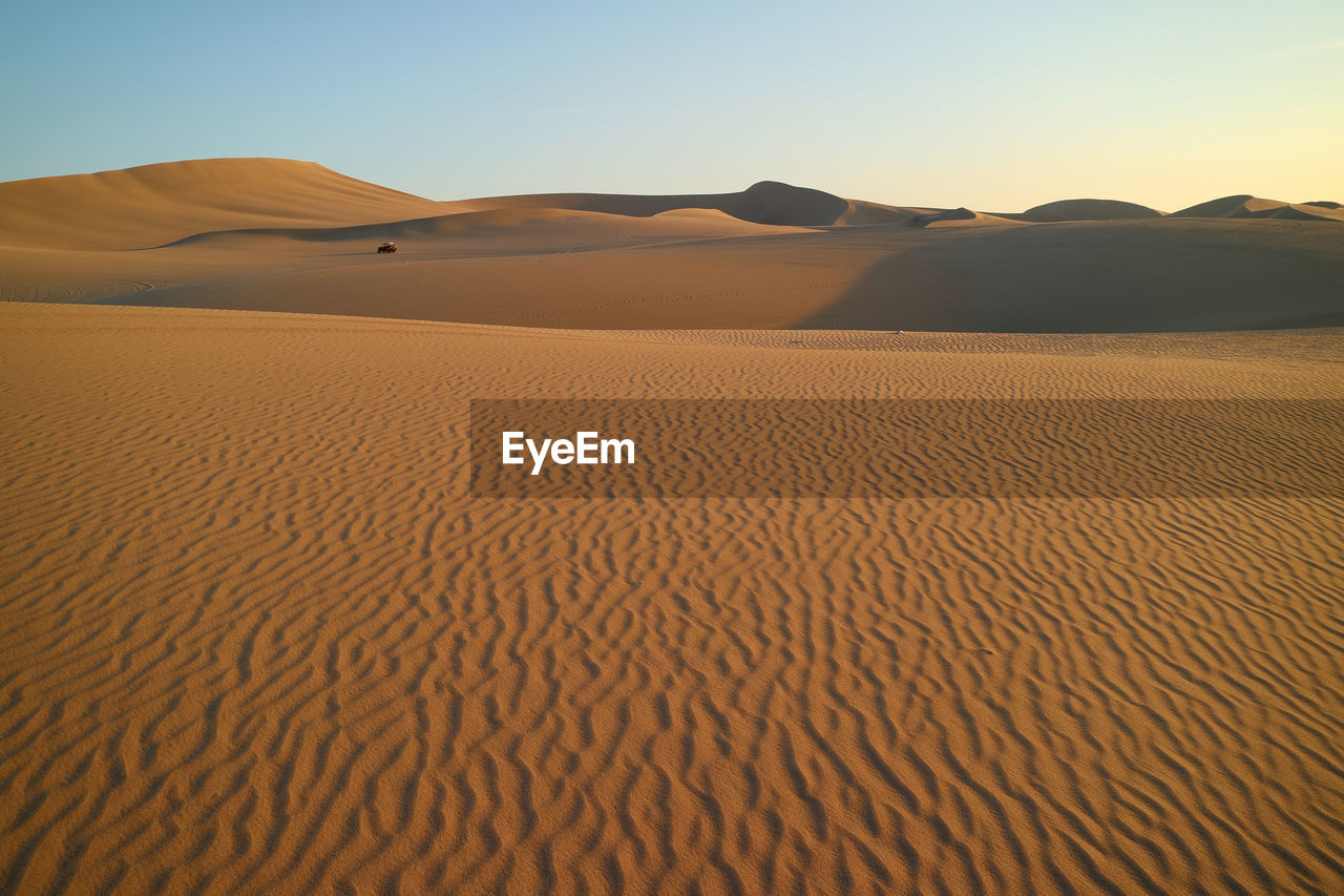 Sand dune in desert against clear sky