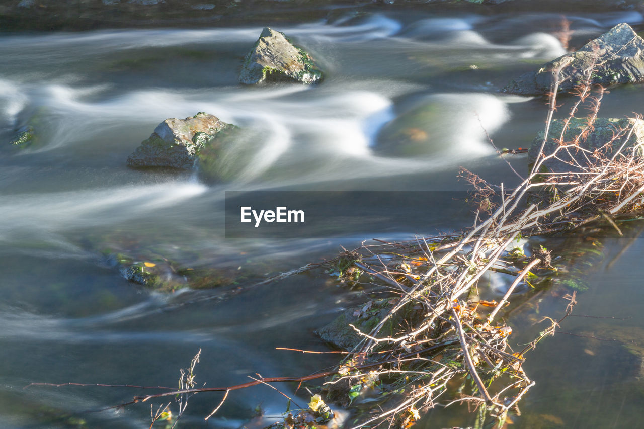 HIGH ANGLE VIEW OF ROCKS BY LAKE