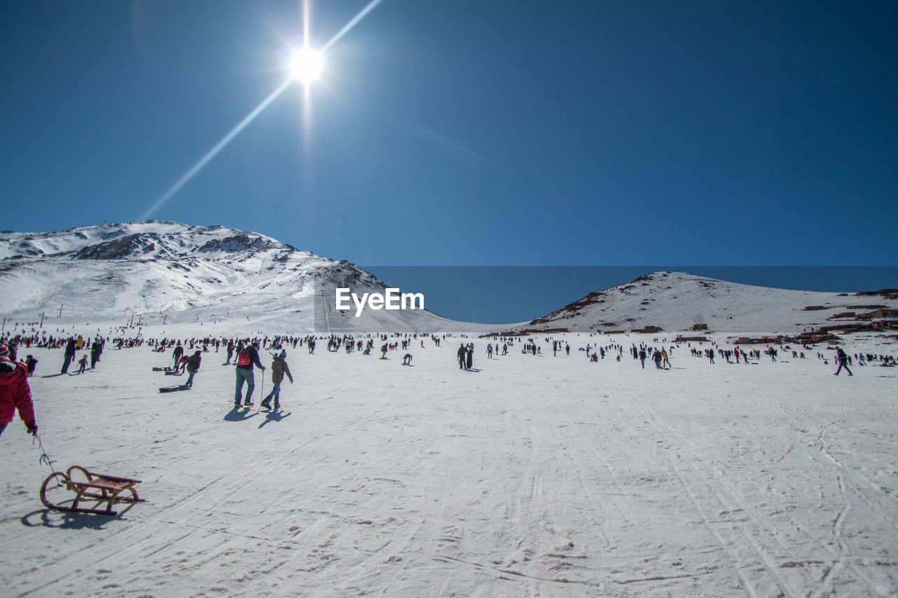 People on snowcapped mountain against sky