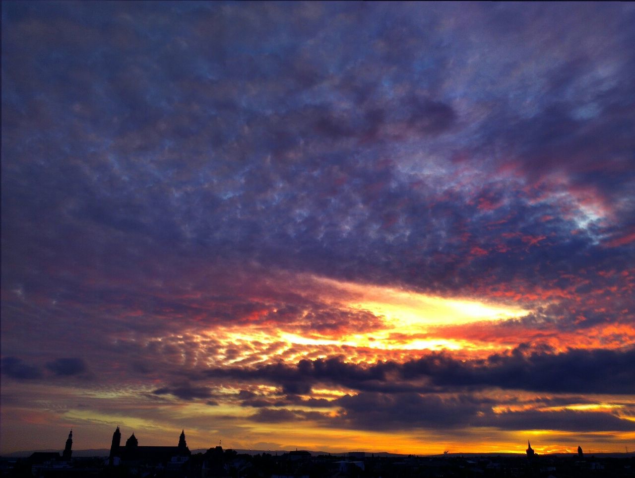 Dramatic sunset sky over city silhouette