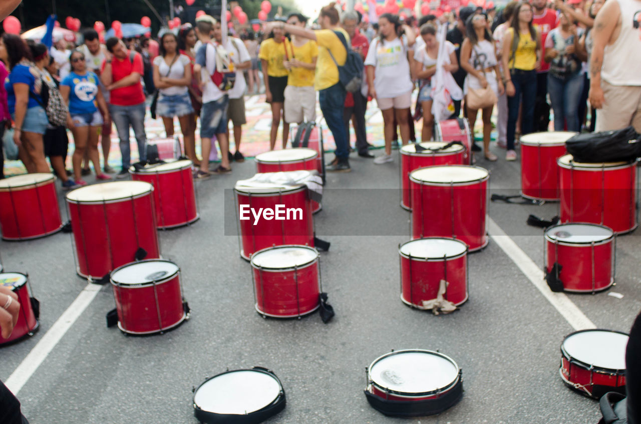 Red drums on street against crowd
