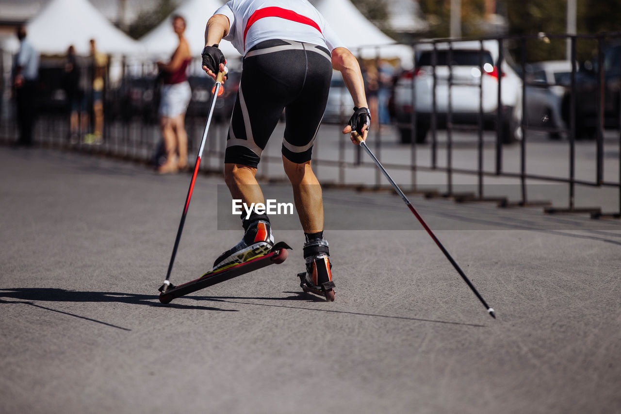 Back man skier in roller skiing race