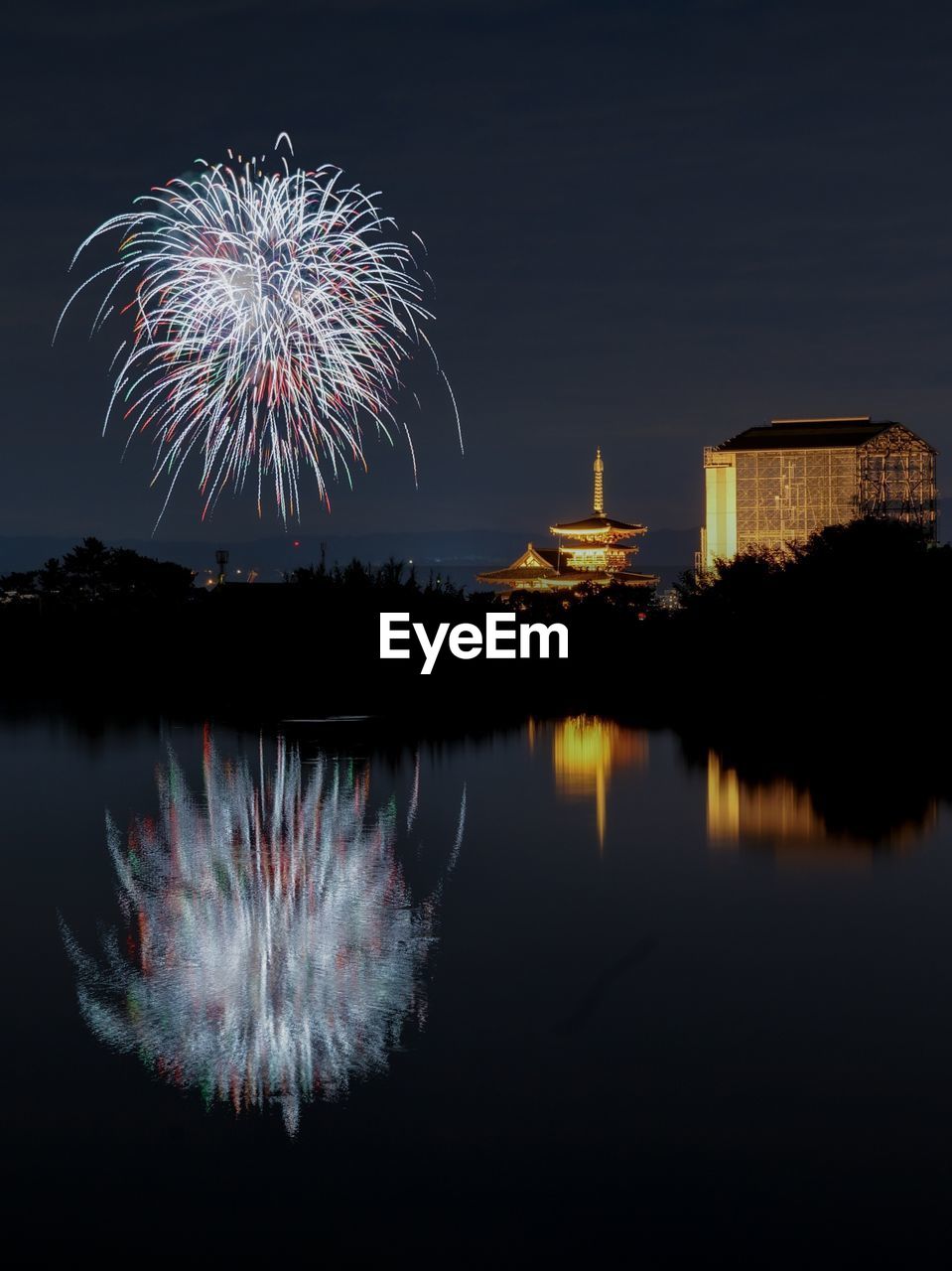 FIREWORK DISPLAY OVER LAKE AGAINST SKY