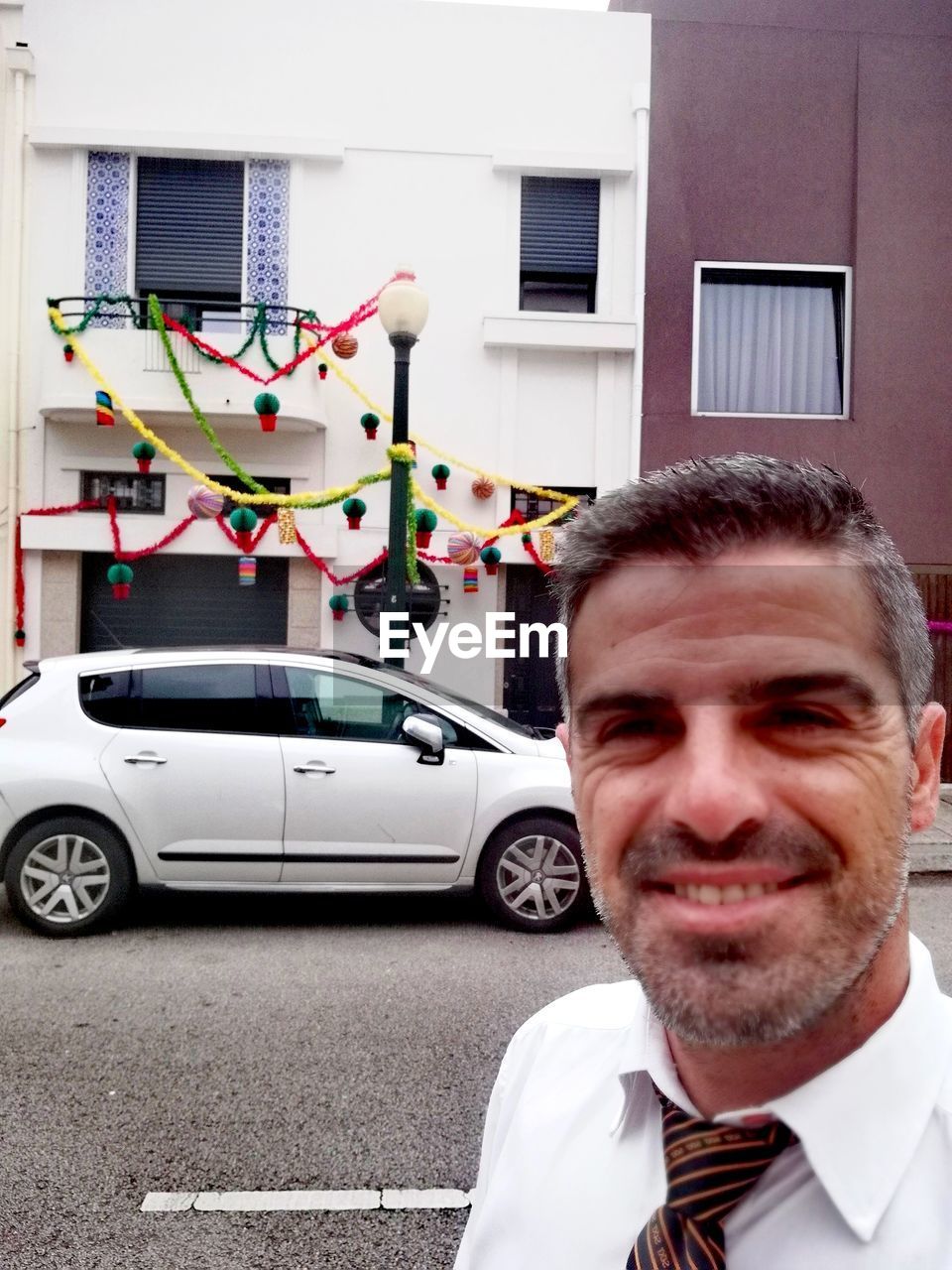 PORTRAIT OF SMILING MAN WITH UMBRELLA