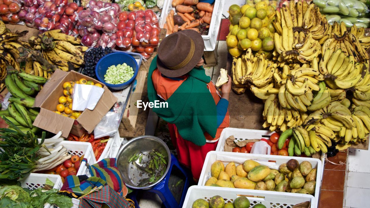 High angle view of woman buying fruits at market stall