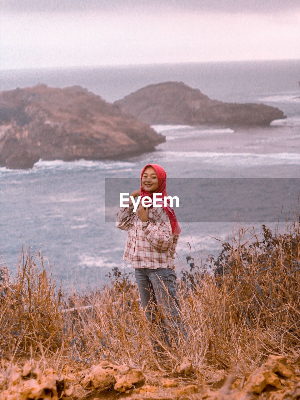 MAN STANDING ON MOUNTAIN AGAINST SKY