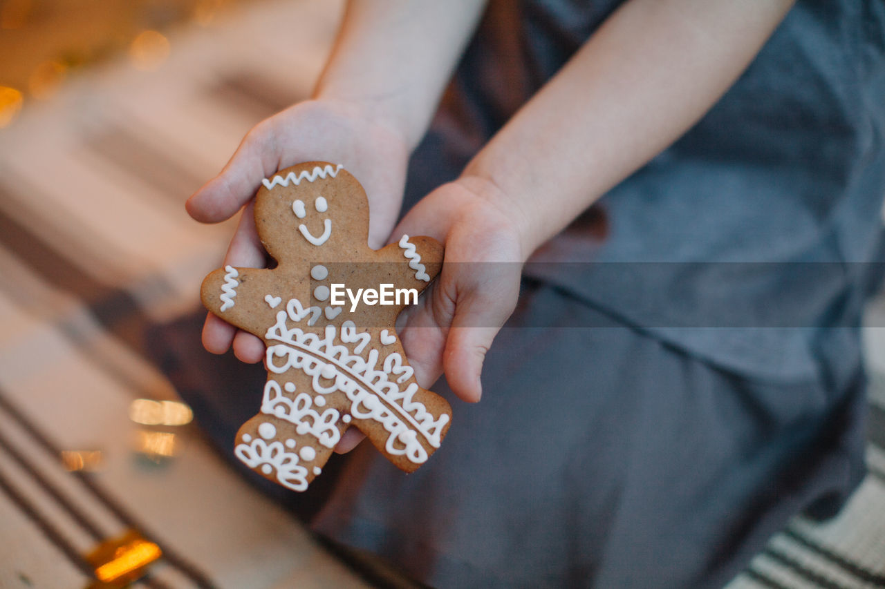 Midsection of woman holding gingerbread cookie