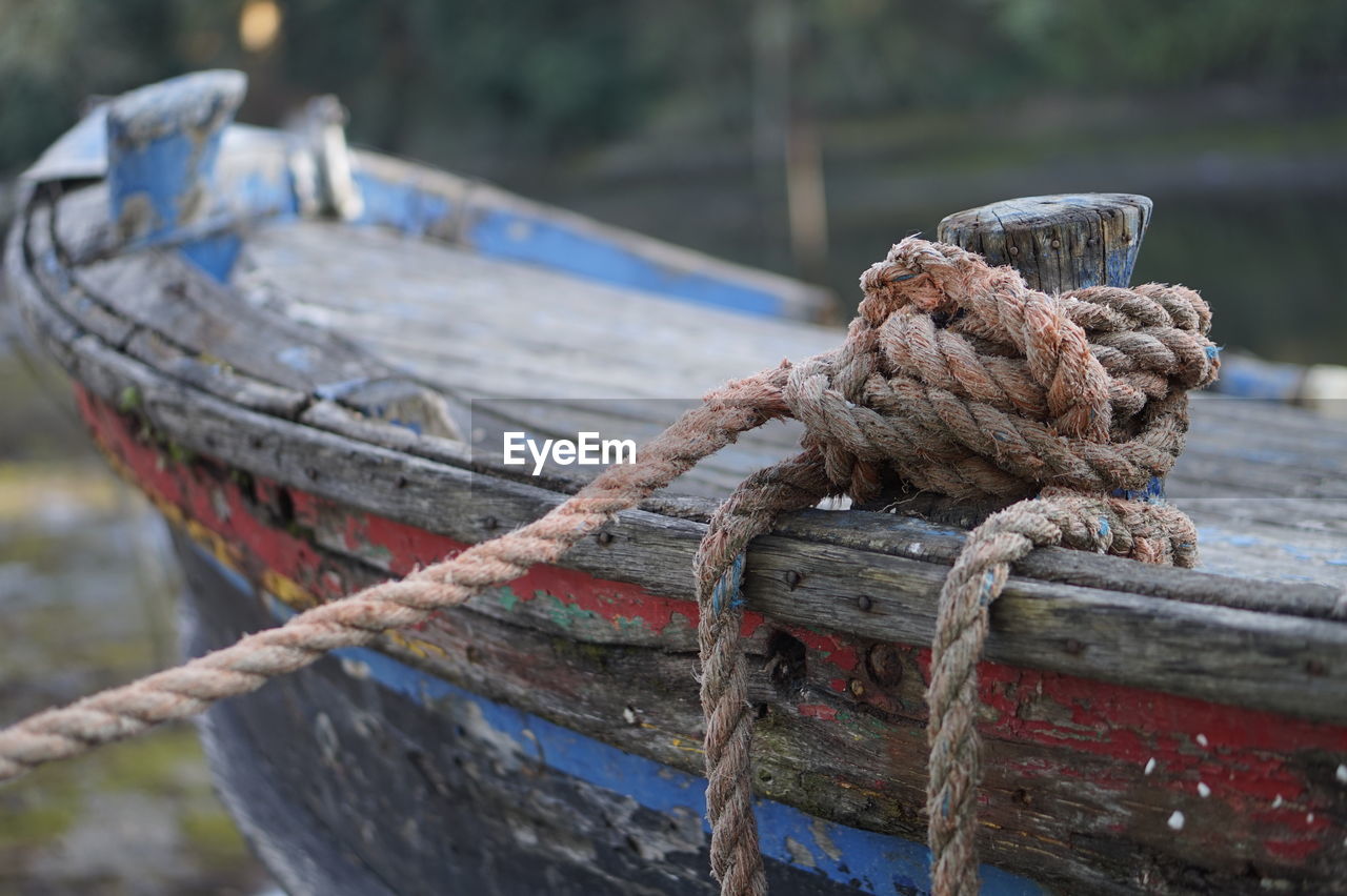 Close-up of rope tied to boat moored at harbor