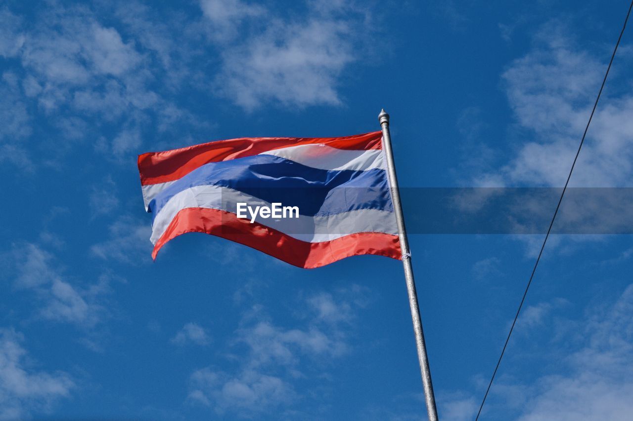 Low angle view of flag against blue sky