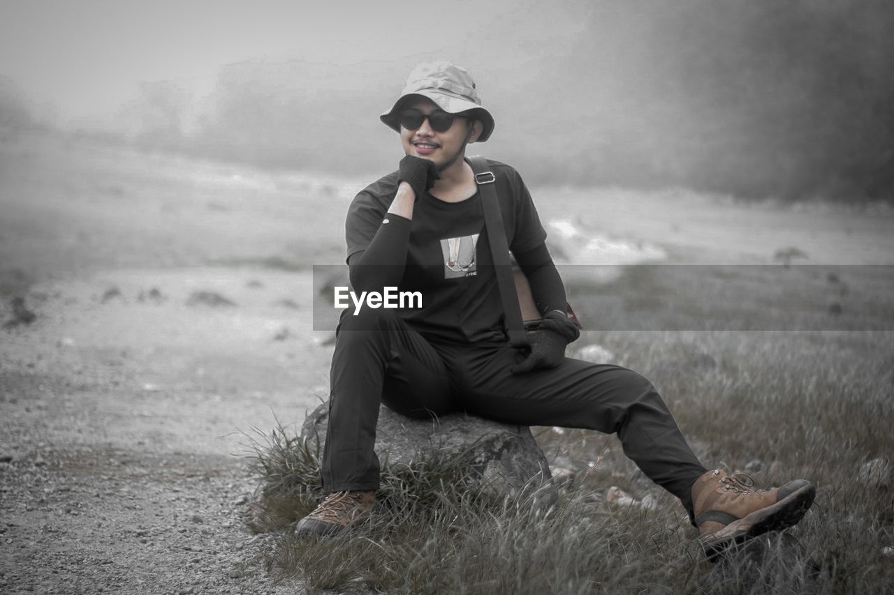 Young man sitting on field