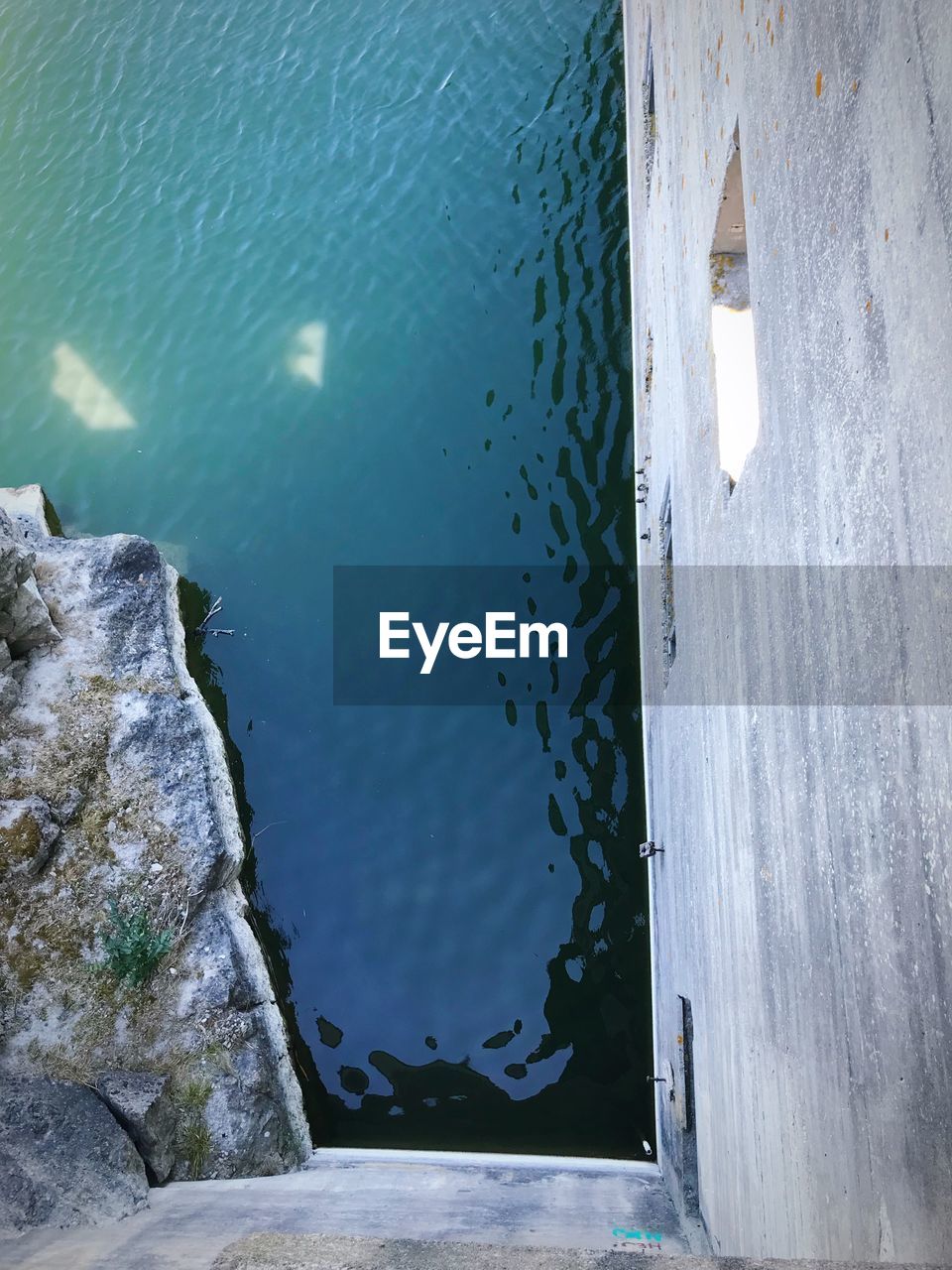 HIGH ANGLE VIEW OF ROCKS IN SEA