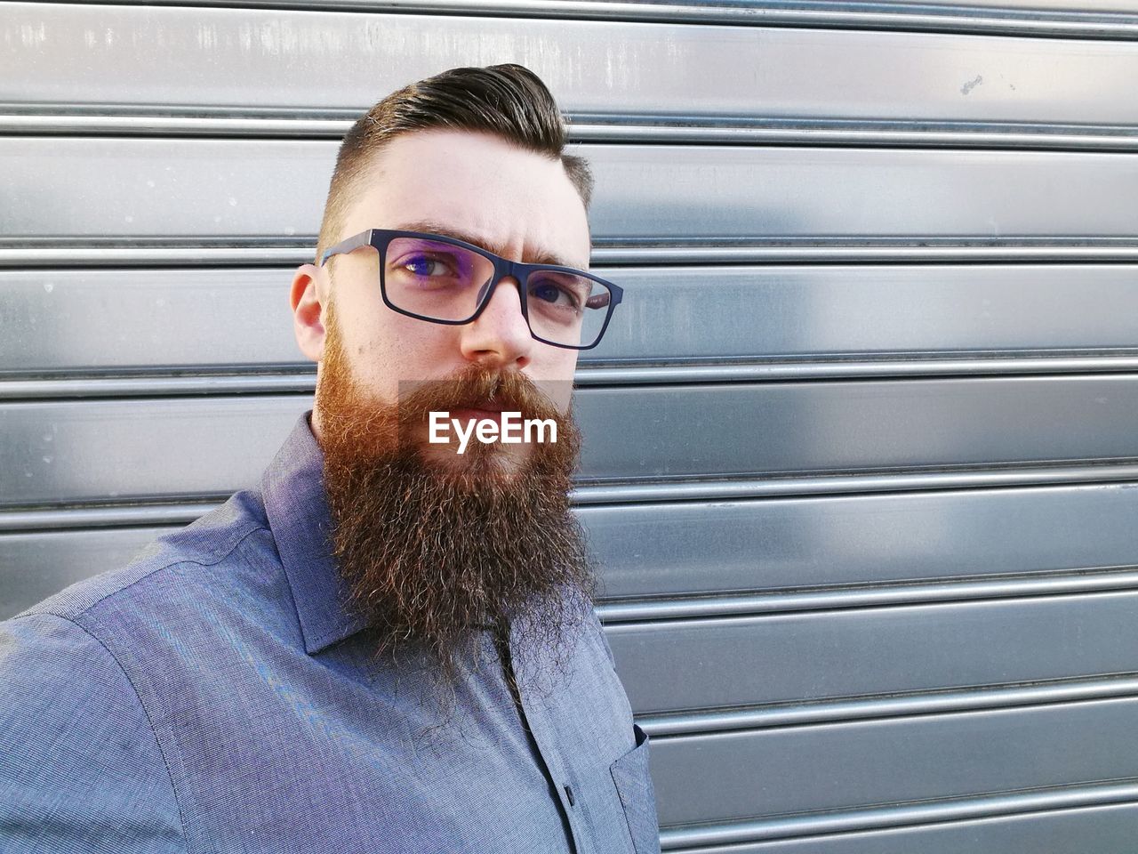 Portrait of bearded man against shutter