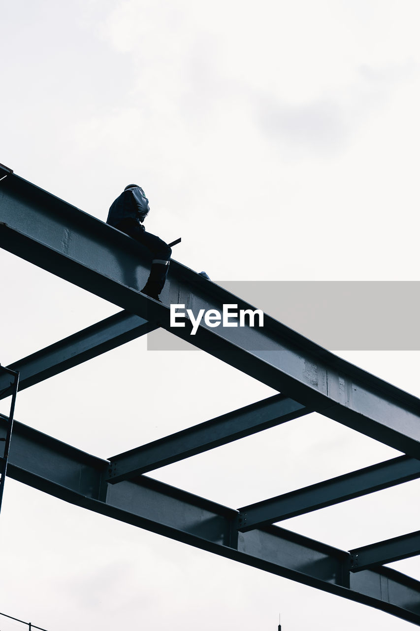 LOW ANGLE VIEW OF CRANE AGAINST SKY