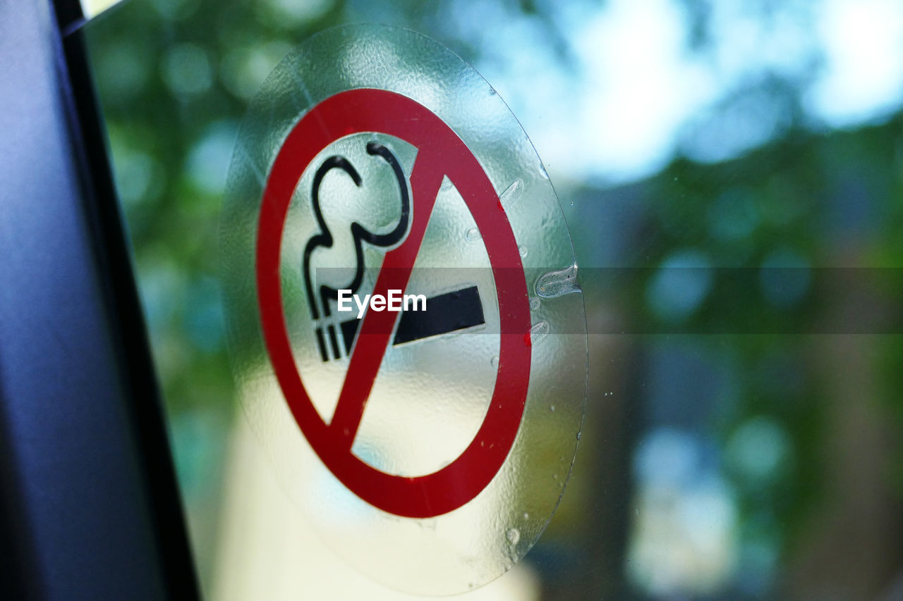 Close-up of warning sign on glass