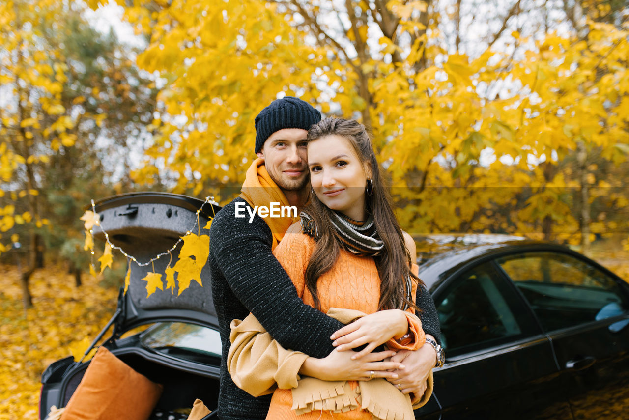 A young couple in love embraces in the autumn forest, walking and enjoying nature