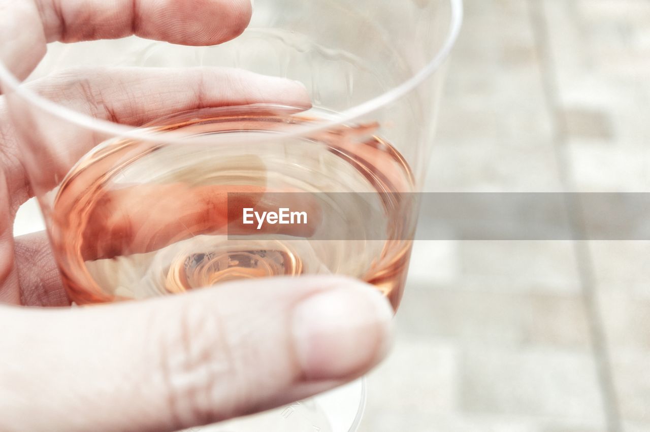 Close-up of hand holding drink in glass