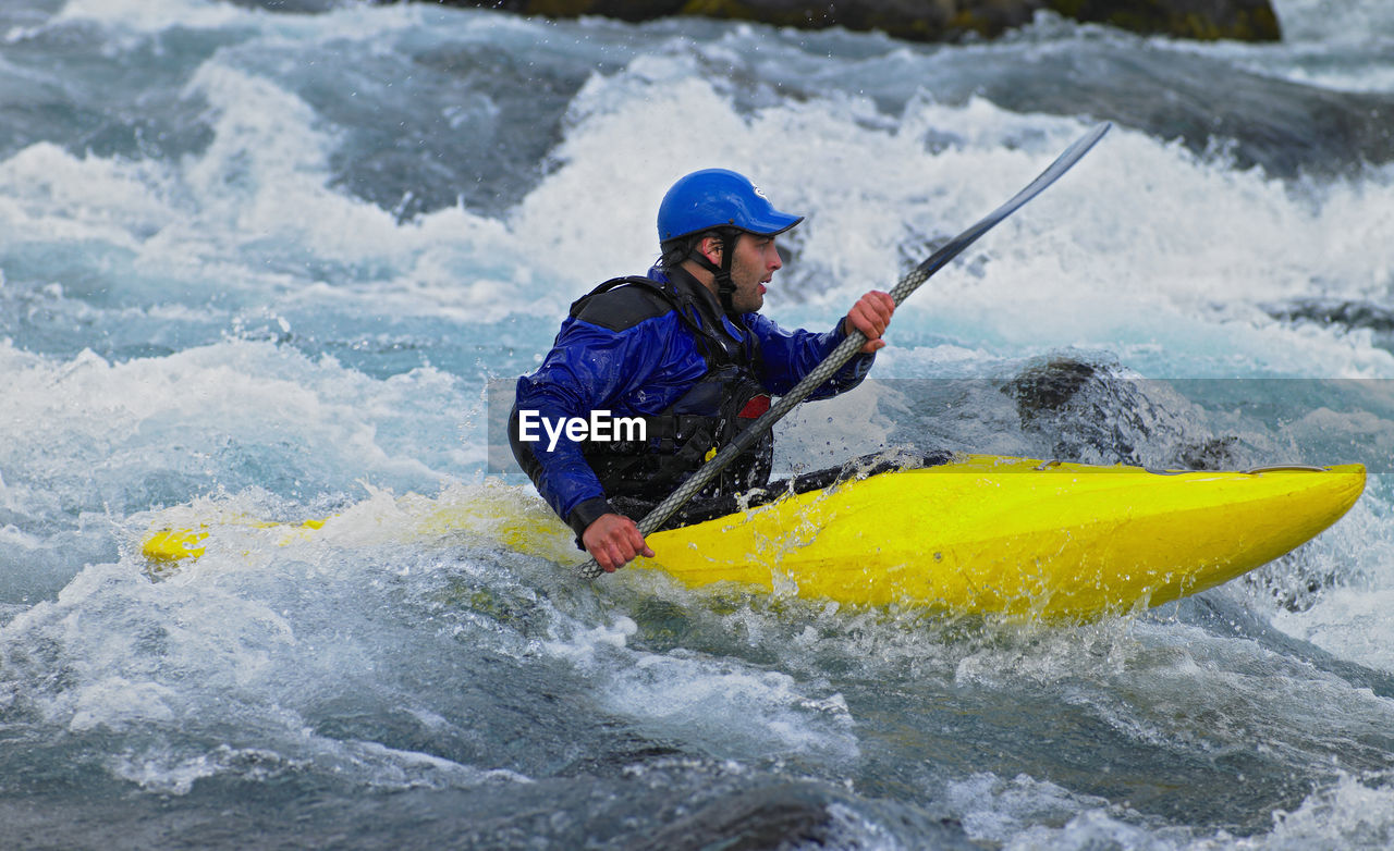 Man going on his white water kayak rapids in an icelandic river