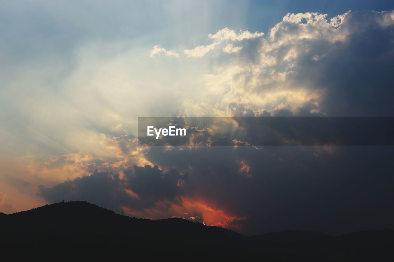 Low angle view of silhouette mountain against dramatic sky