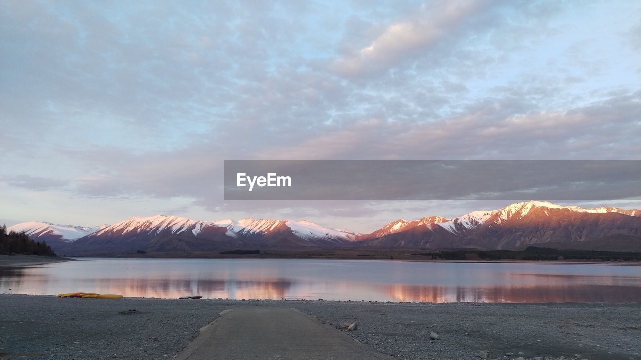 View of calm lake against cloudy sky