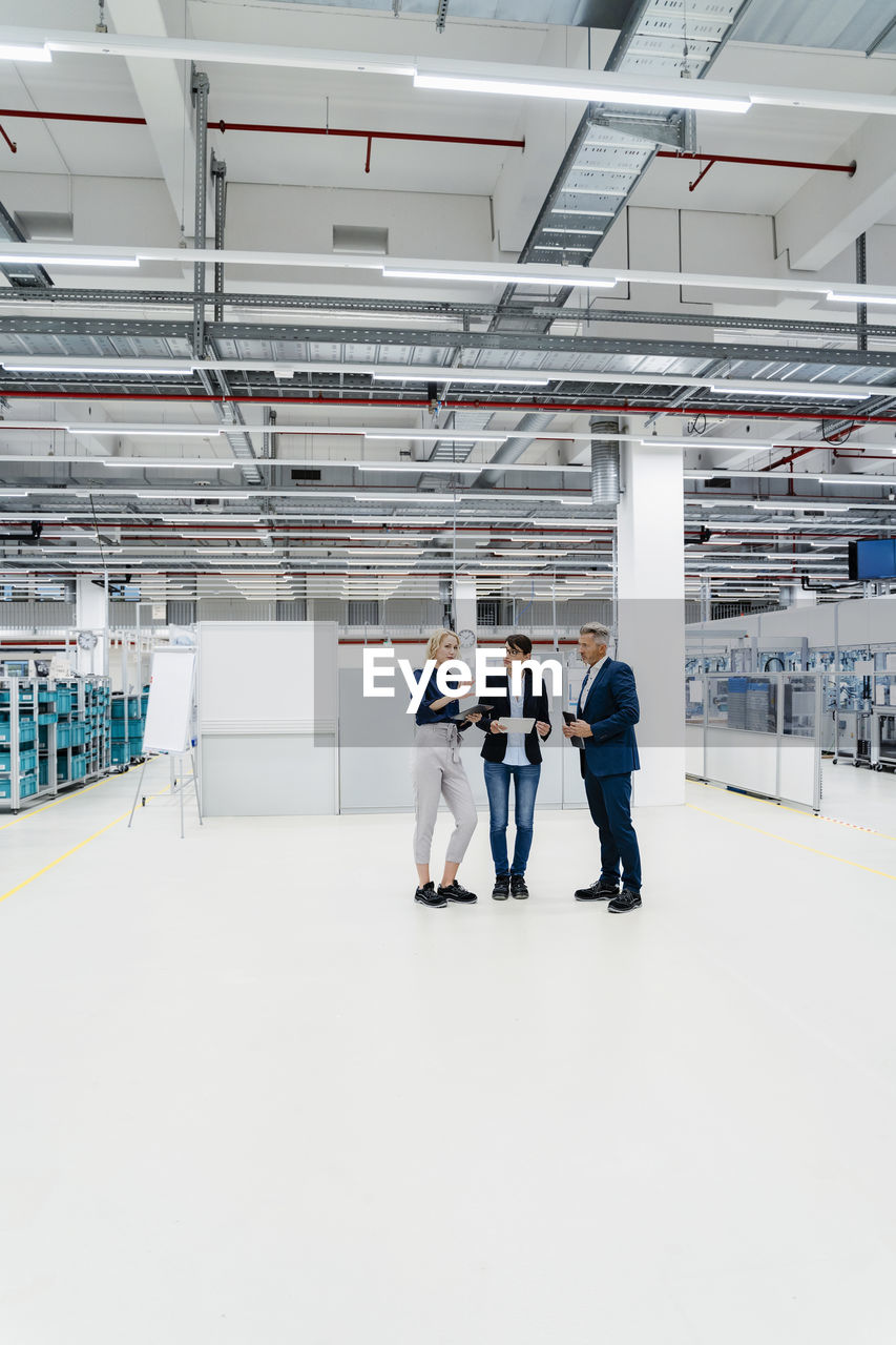 Businesswoman discussing with colleagues in modern industry