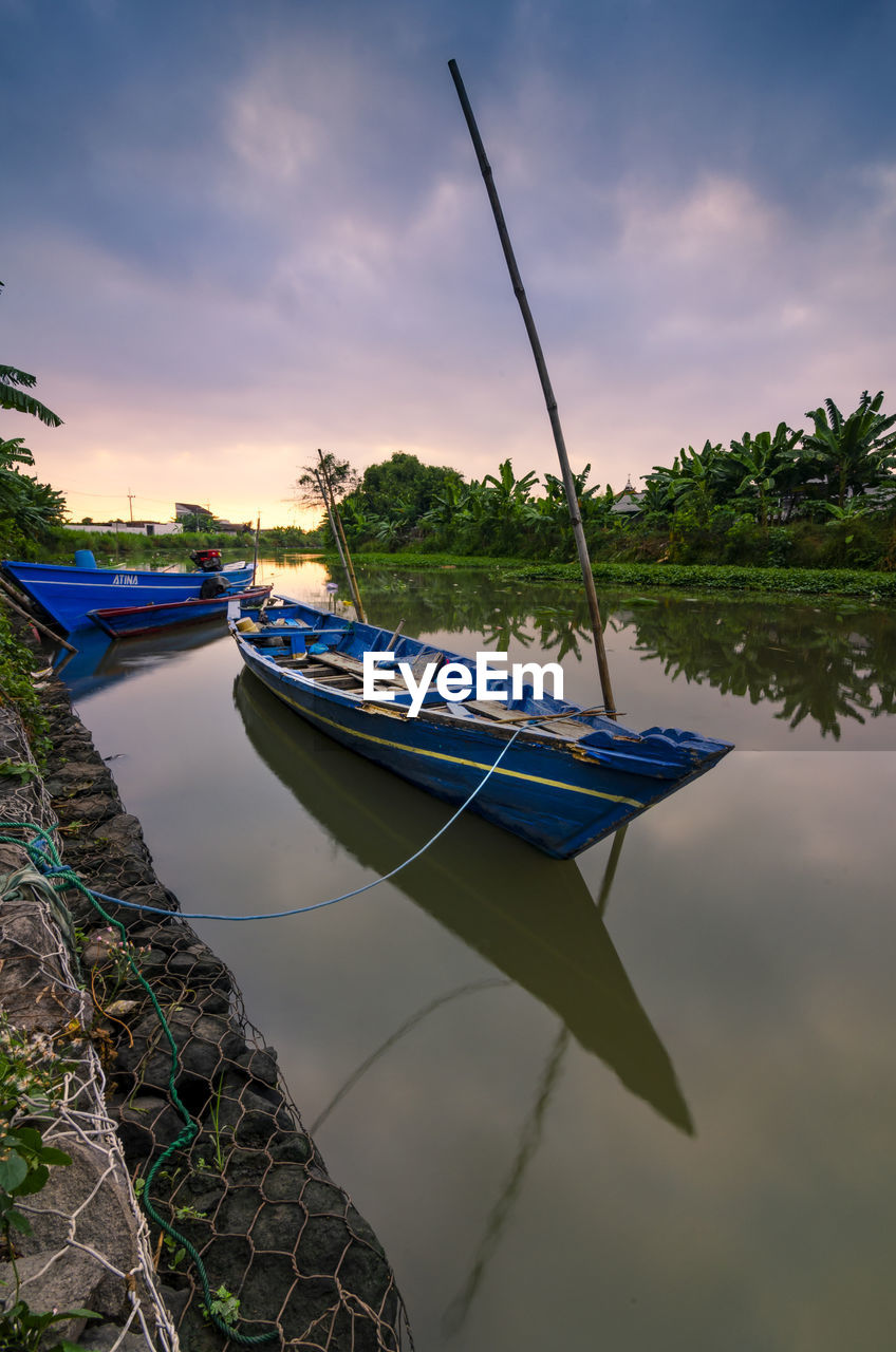 Boats moored in lake against sky