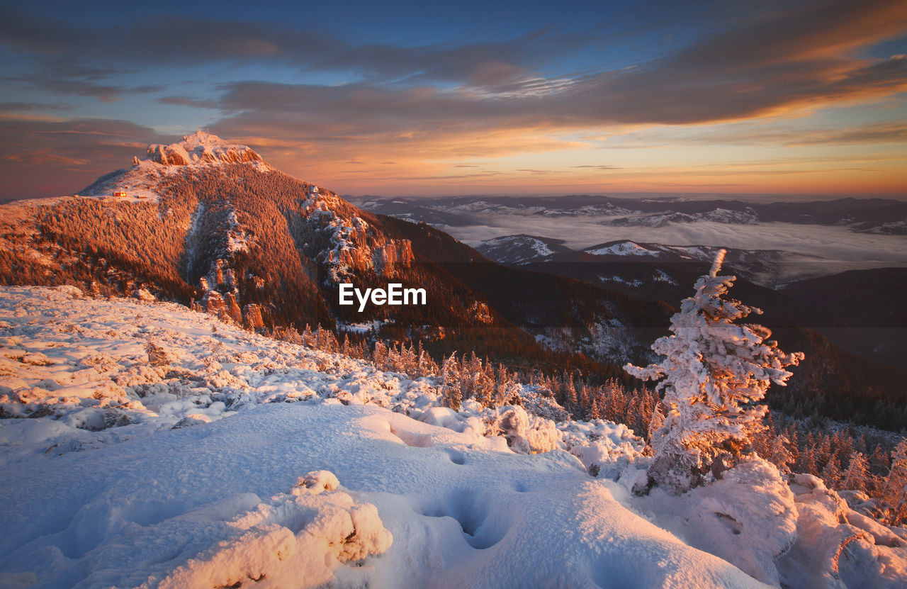 Scenic view of snow mountains against sky during sunset