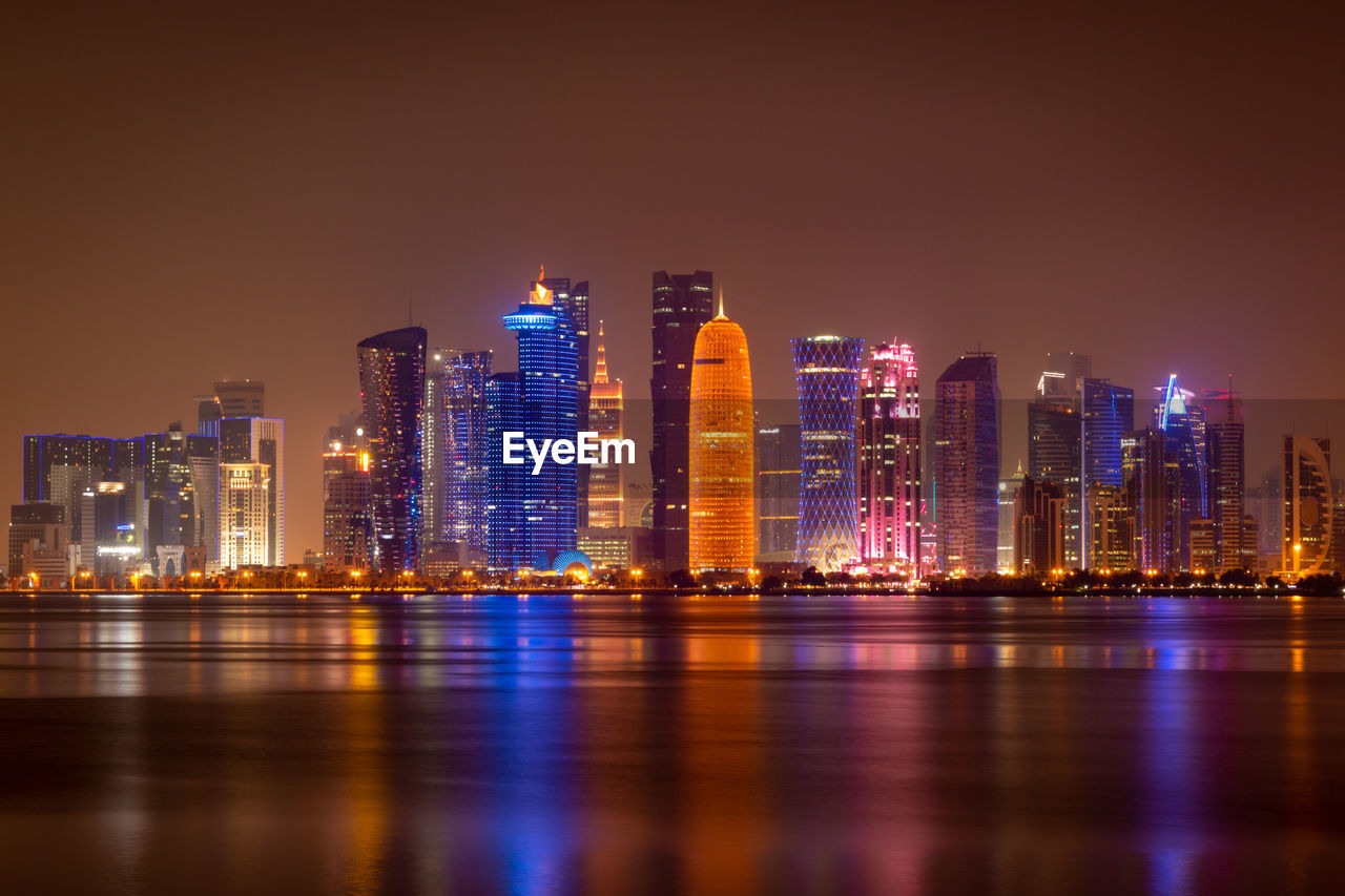 Coloful illuminated skyline of doha at night, qatar, middle east against dark sky