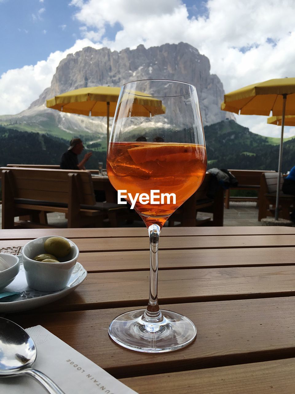 Close-up of wineglass on table against sky