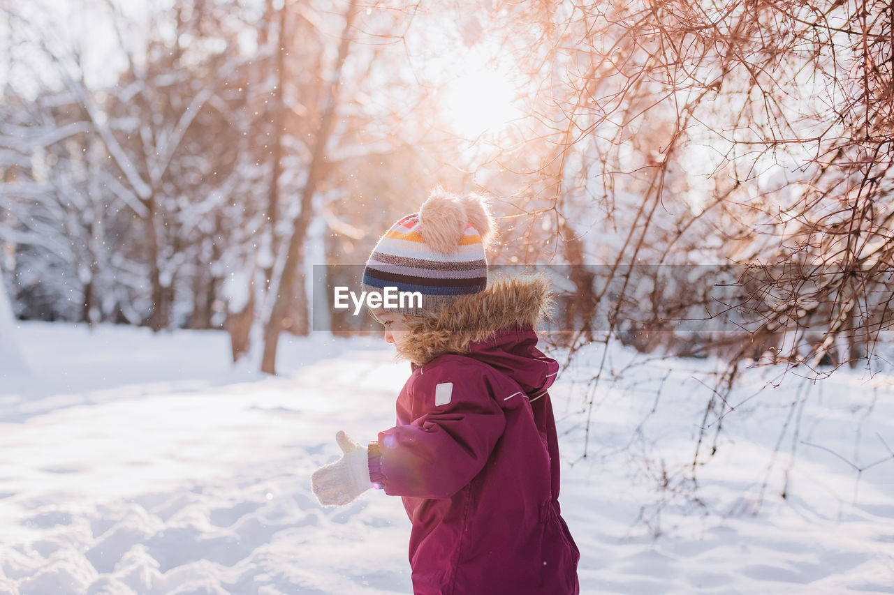 Rear view of woman standing on snow covered landscape