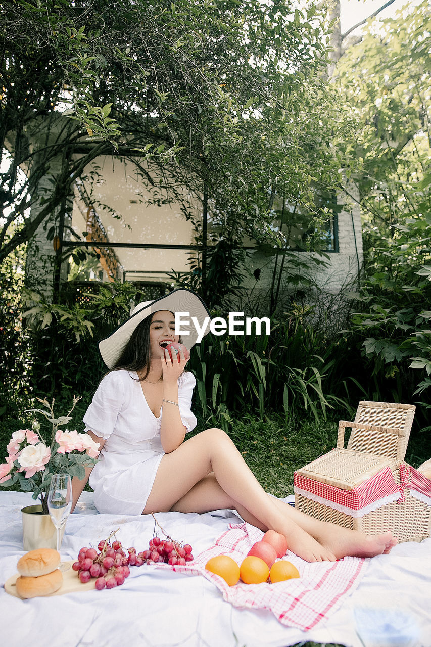 Woman sitting on table against plants