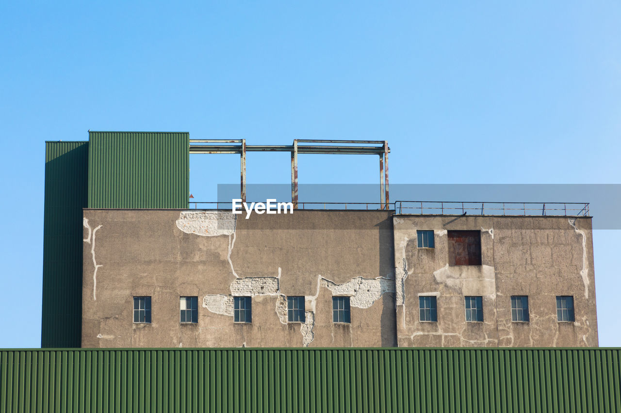 Low angle view of old building against clear blue sky