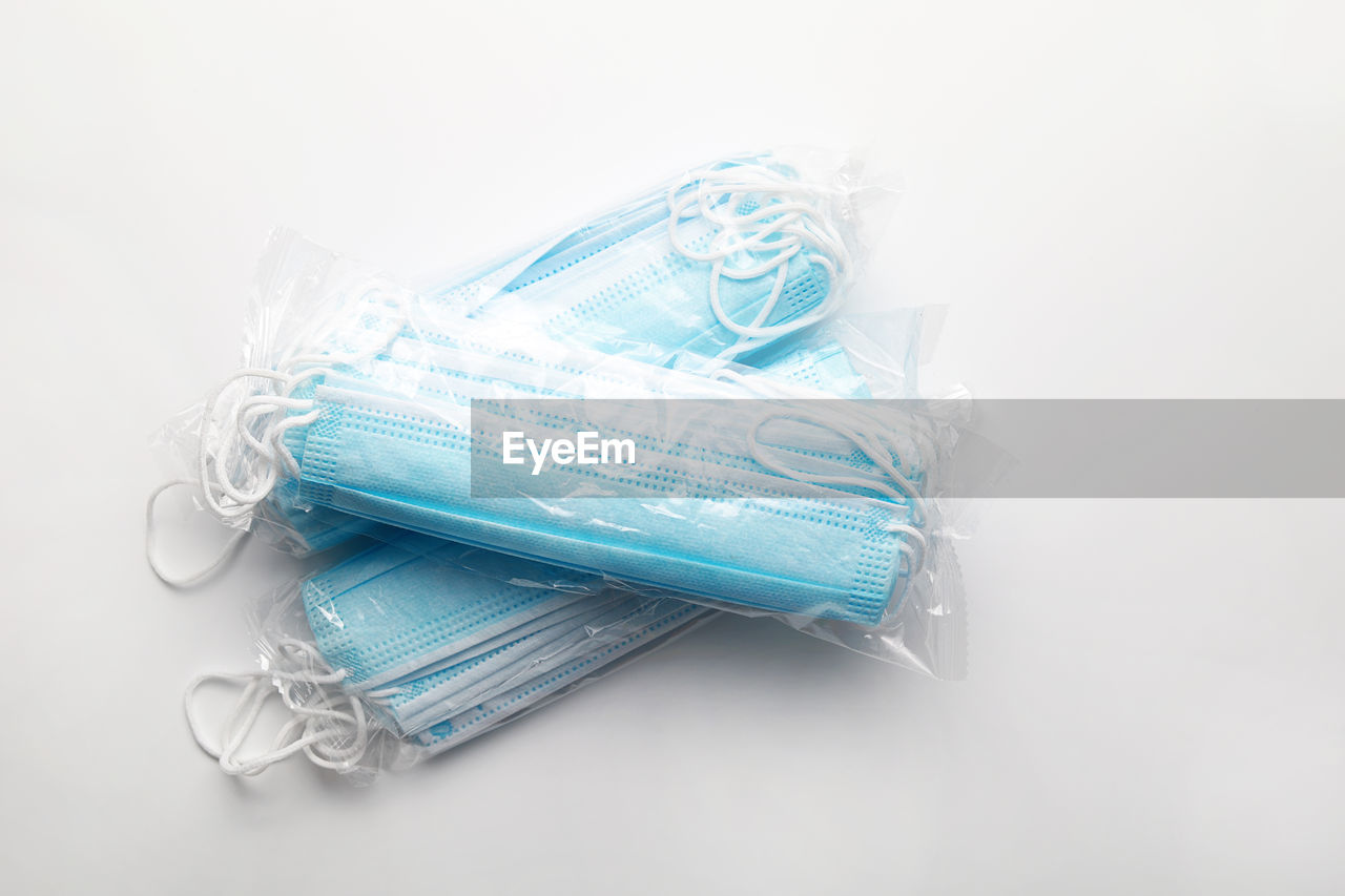 HIGH ANGLE VIEW OF BLUE PLASTIC ON WHITE BACKGROUND