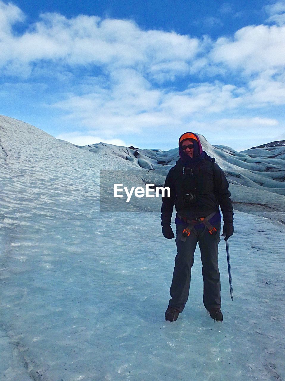 MAN STANDING ON SNOW COVERED MOUNTAIN