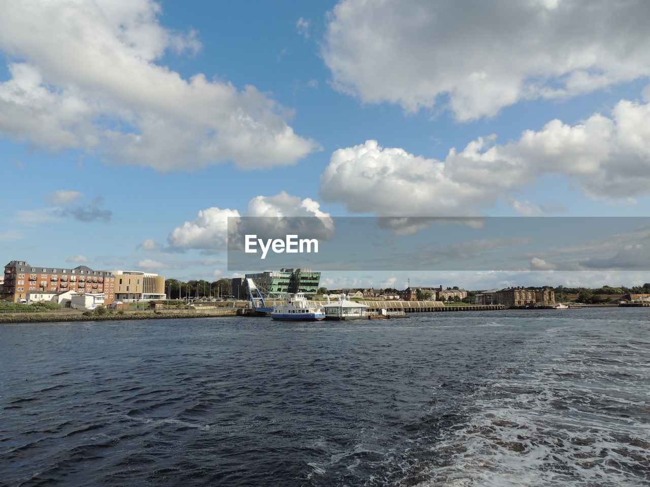 SEA BY BUILDINGS AGAINST SKY