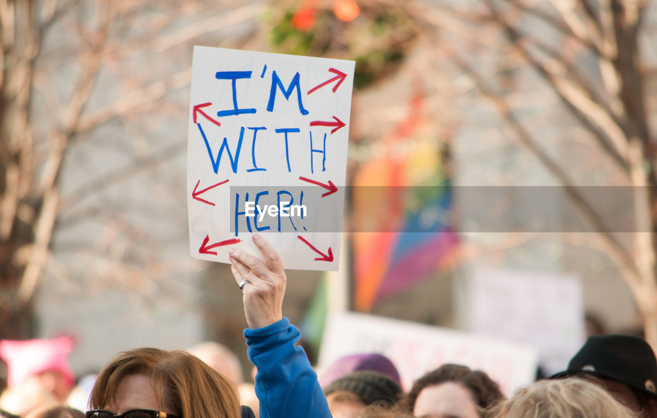 Cropped hand holding paper with text during protest in city