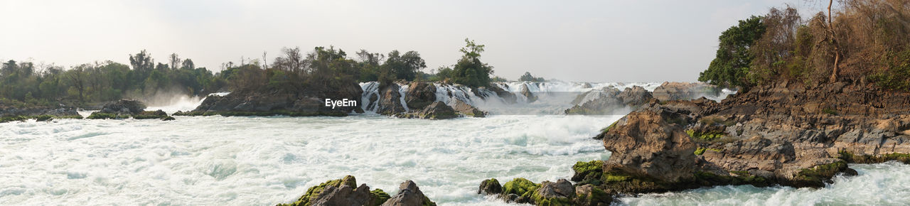 PANORAMIC VIEW OF WATERFALL AGAINST TREES