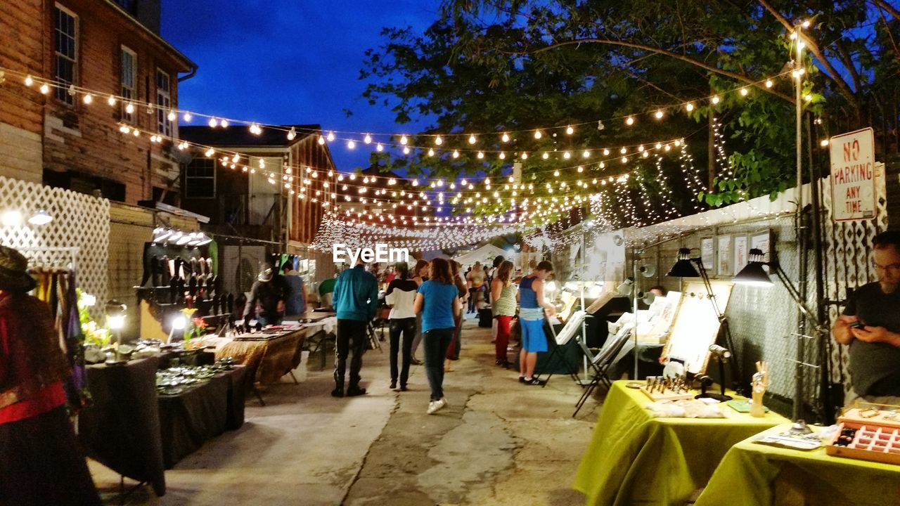 People in illuminated market at night