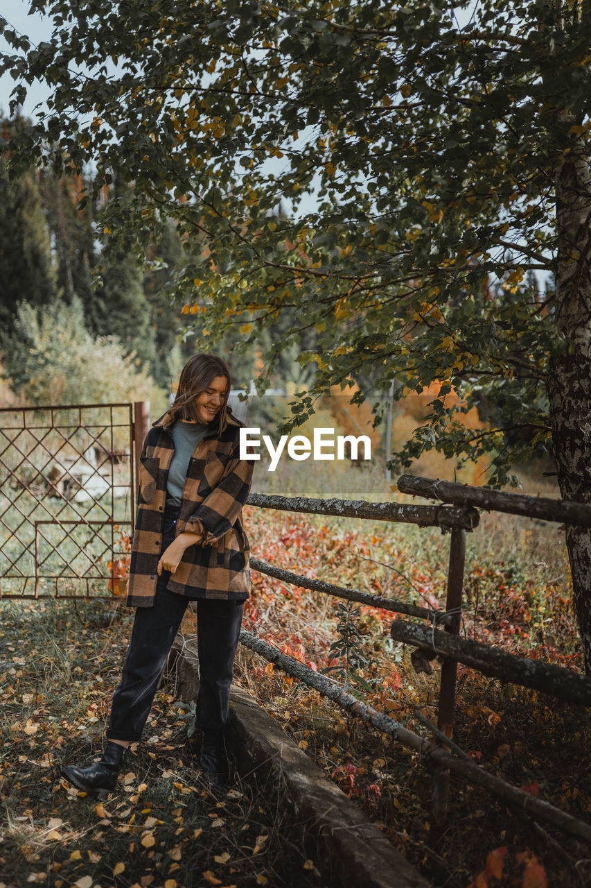 Portrait of man standing by tree during autumn