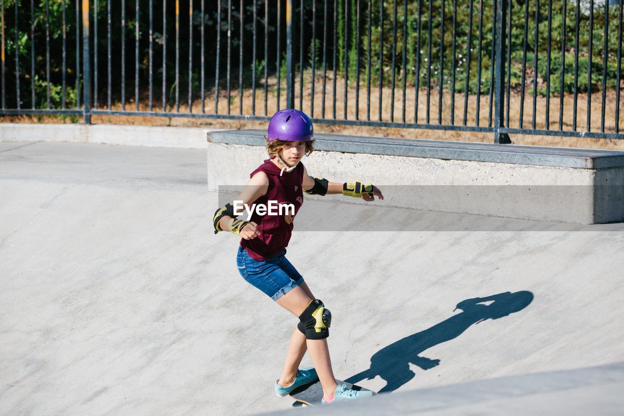 Teen girl focused as she is skateboarding at the skatepark