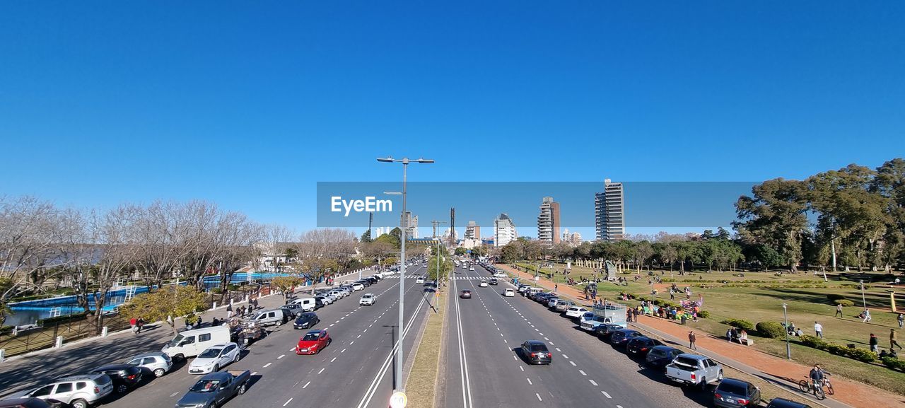 VEHICLES ON ROAD AGAINST BLUE SKY