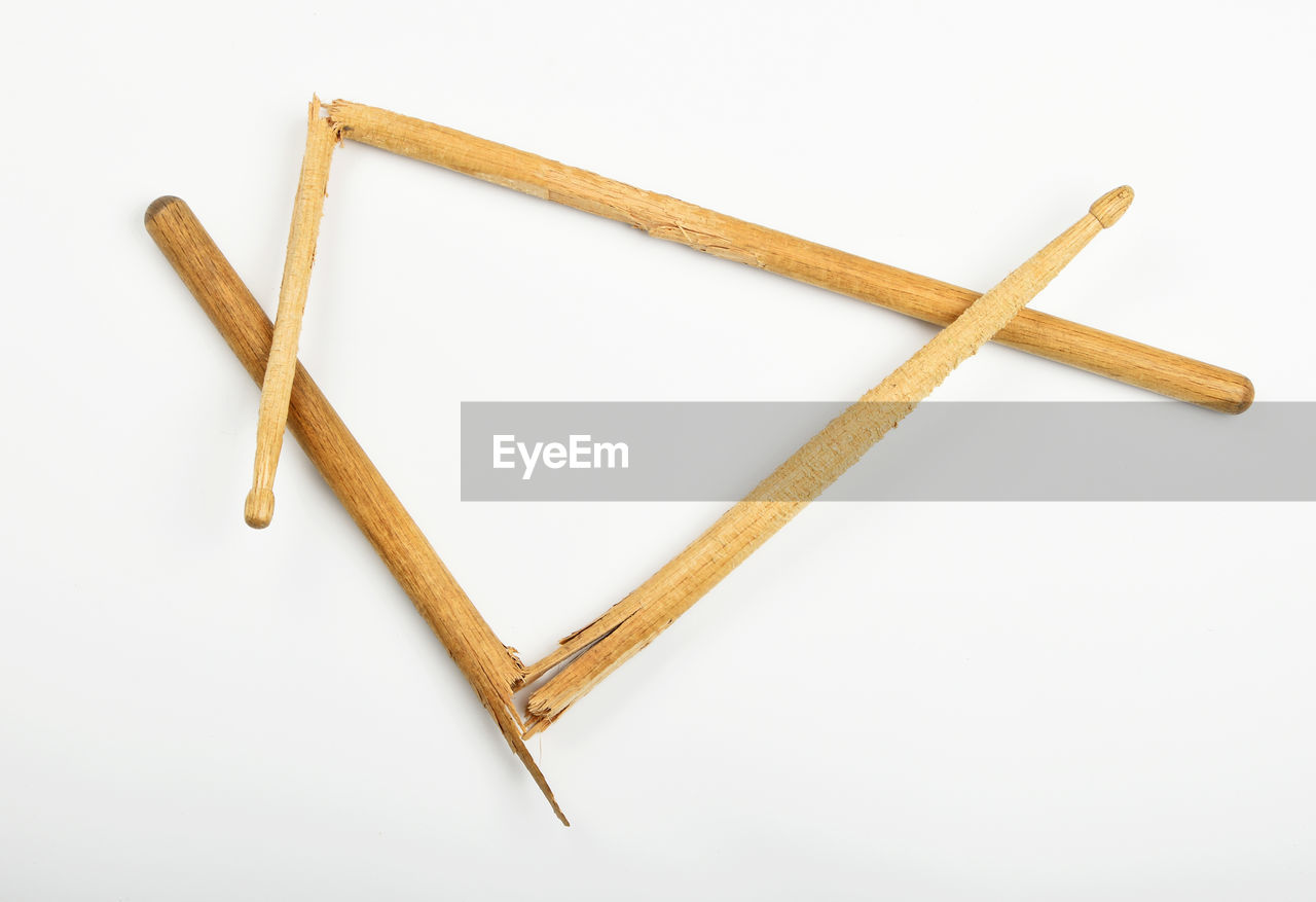 High angle view of broken drumsticks on white background