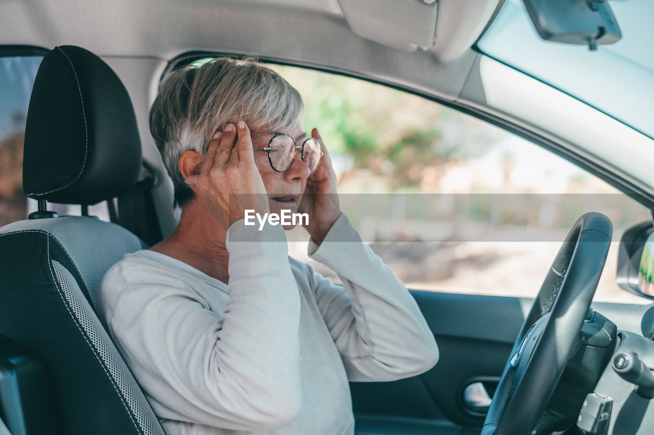 Senior woman sitting in car