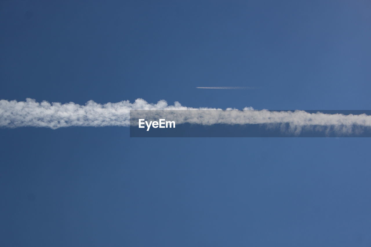 Low angle view of vapor trail in blue sky