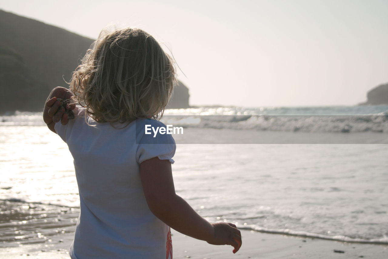 Rear view of girl looking at sea shore